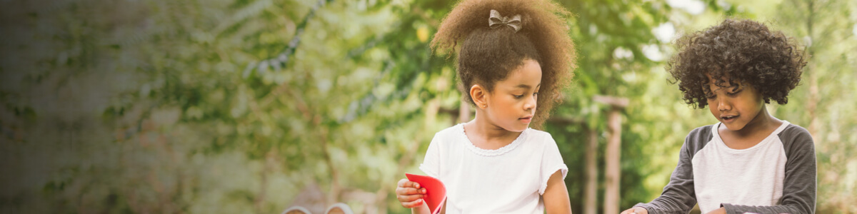 Two children reading outside