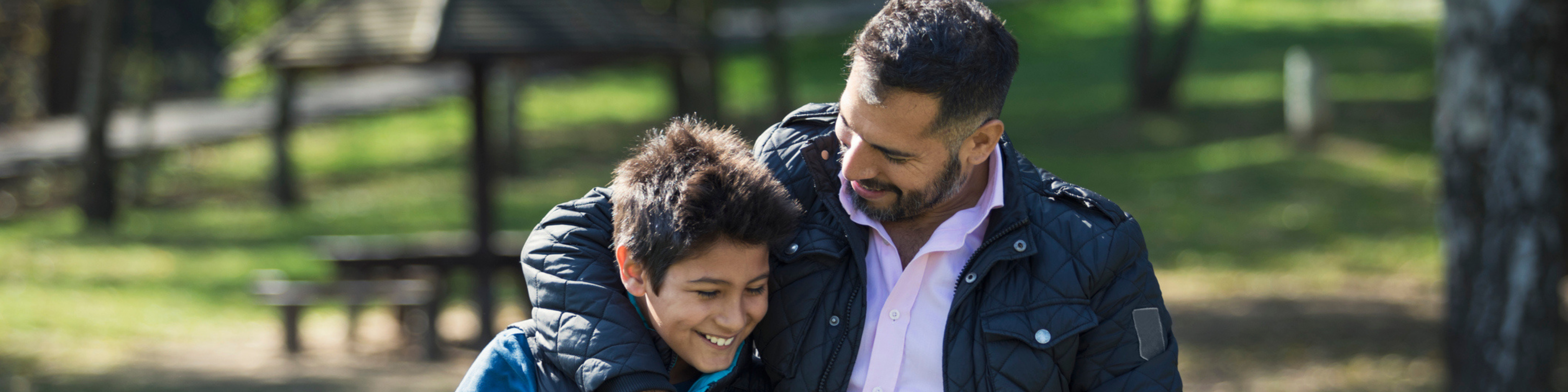 Father and son walking through park